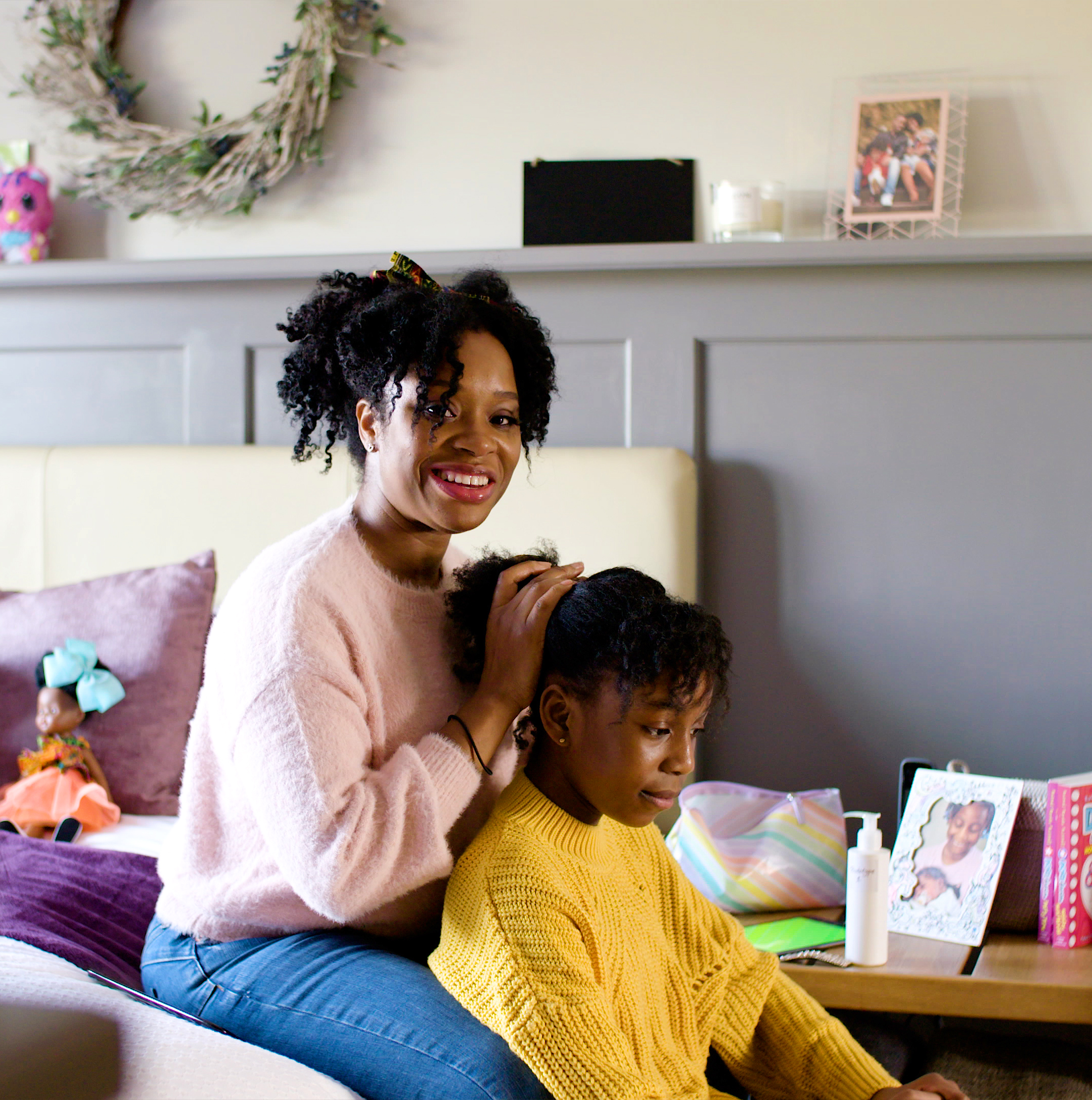 Photo of a smiling woman holding a child’s hair