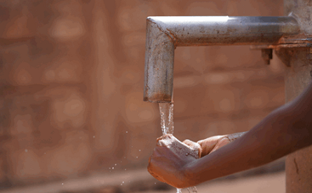 Water coming from tap into hand