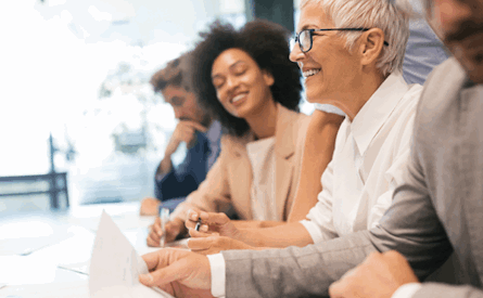 Photo of a line of suited office workers sitting at a table