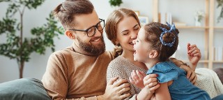 Family sitting on couch laughing